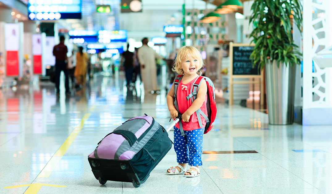 Kids at the airport with suitcase